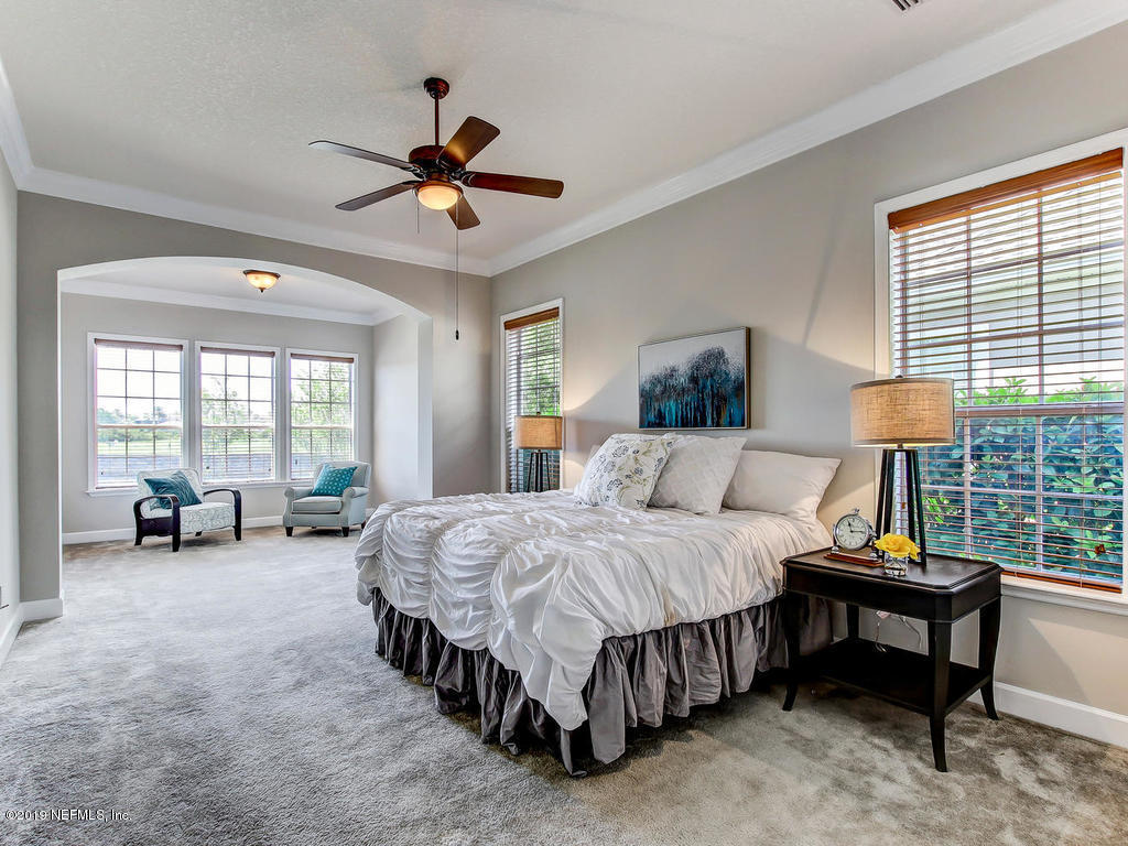 1780 North Loop Parkway St. Augustine, FL 32095 - Photo 6 of 98 a spacious bedroom with a bed and a chandelier