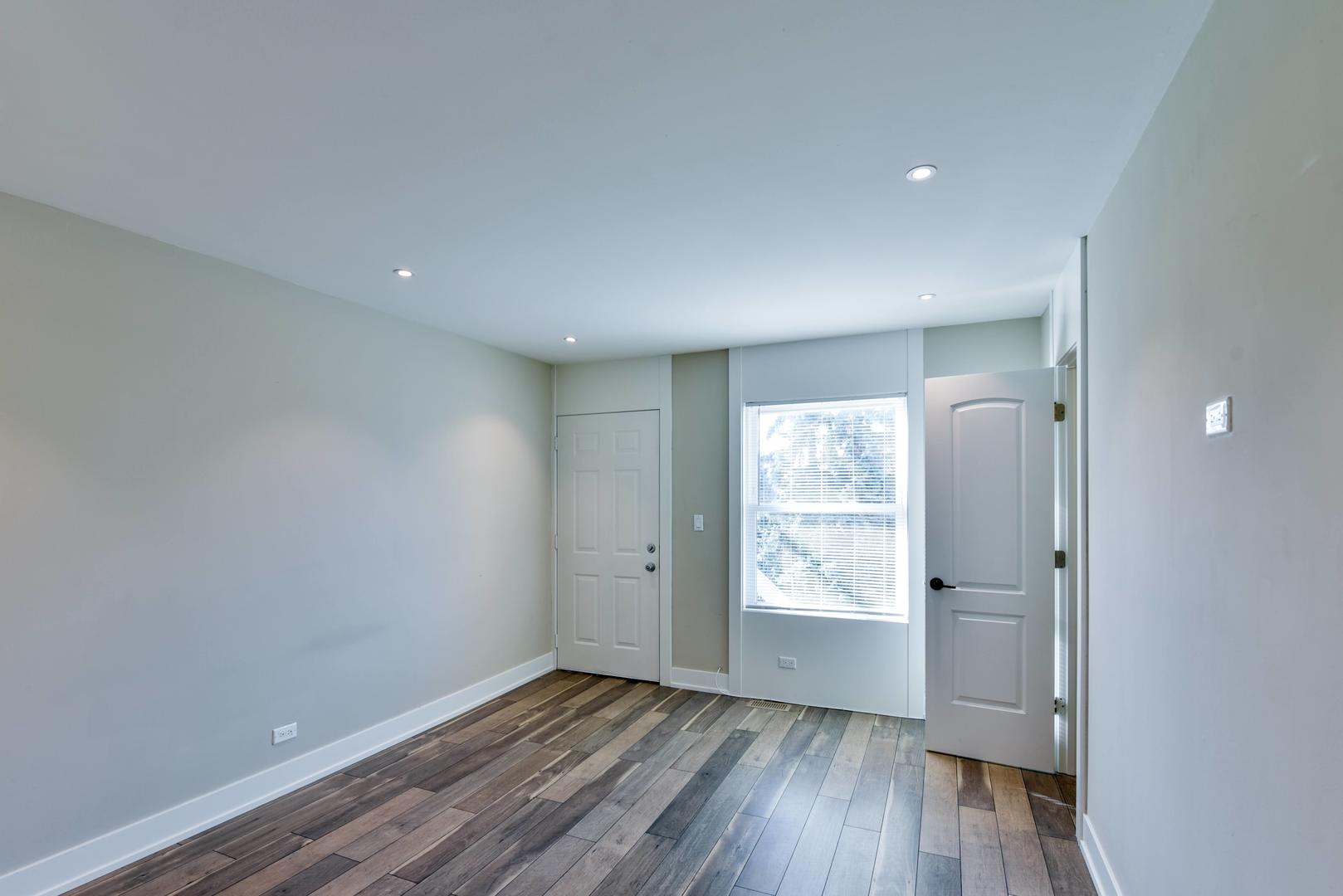 787 Pahl Road, Unit 787 Elk Grove Village, IL 60007 - Photo 20 of 28 an empty room with wooden floor and windows