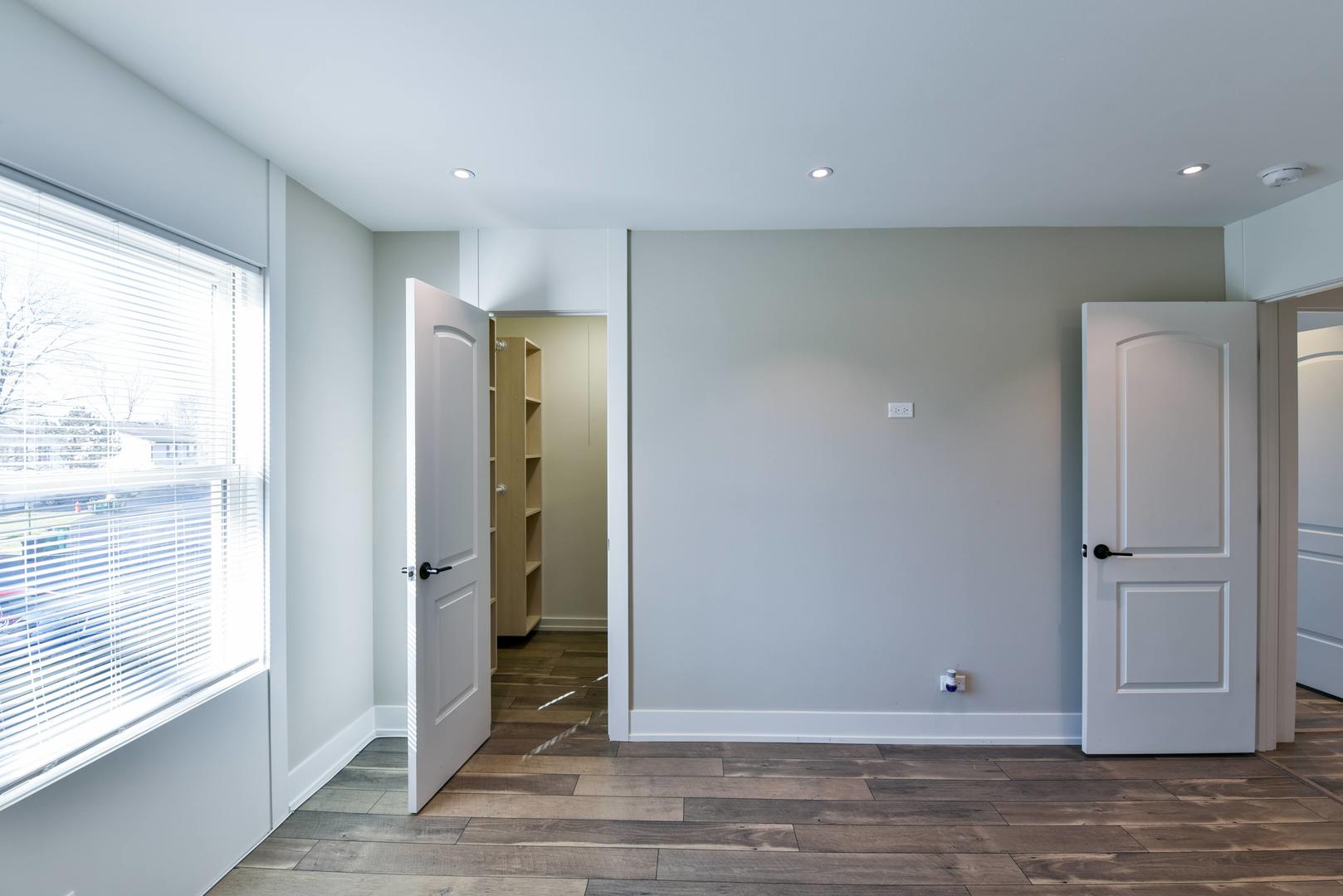 787 Pahl Road, Unit 787 Elk Grove Village, IL 60007 - Photo 21 of 28 a view of an empty room with wooden floor and a window