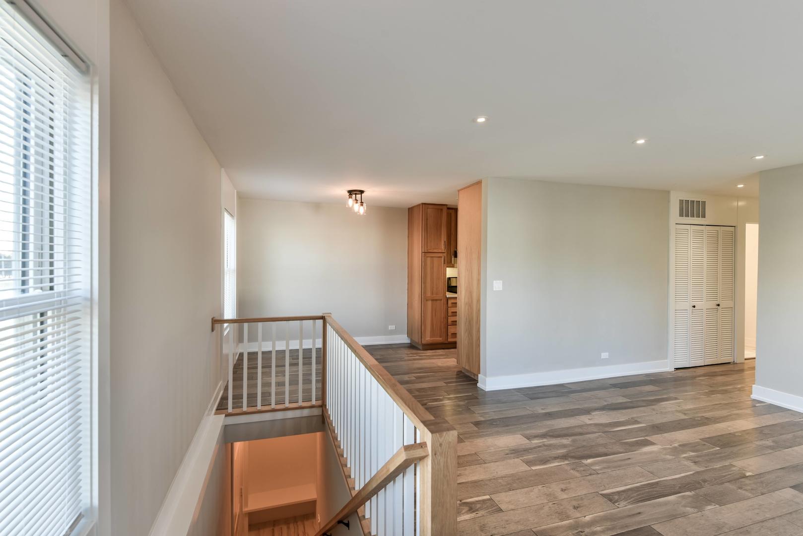 787 Pahl Road, Unit 787 Elk Grove Village, IL 60007 - Photo 4 of 28 a view of a hallway with wooden floor and staircase