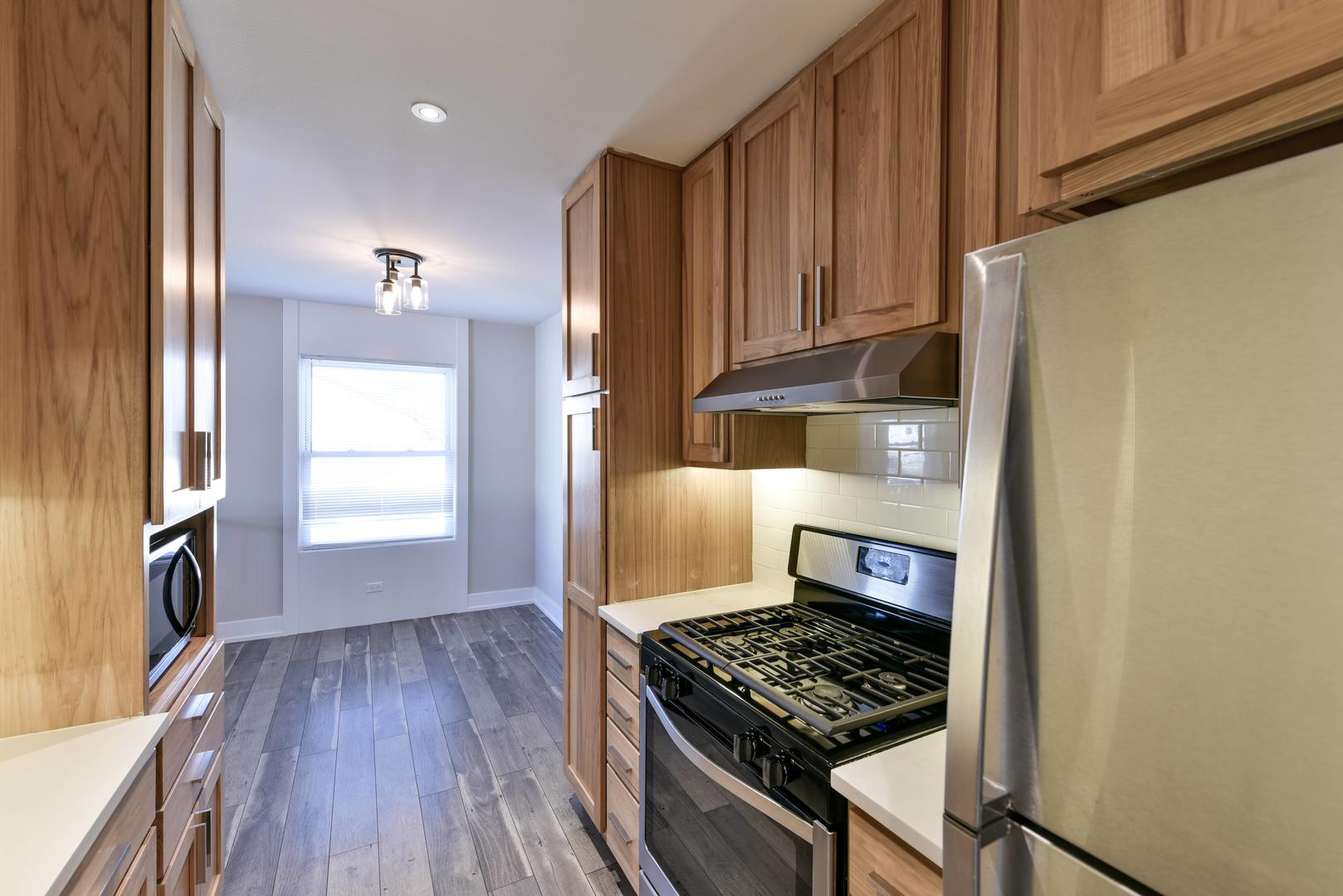 787 Pahl Road, Unit 787 Elk Grove Village, IL 60007 - Photo 9 of 28 a kitchen with wooden cabinets and a stove top oven