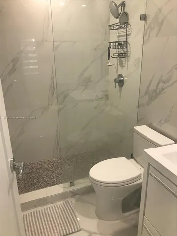 a bathroom with a toilet and a shower