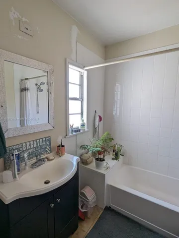 a bathroom with a sink vanity tub and a mirror