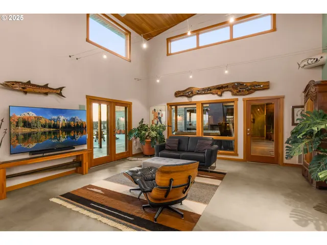 a living room with furniture a flat screen tv and kitchen view