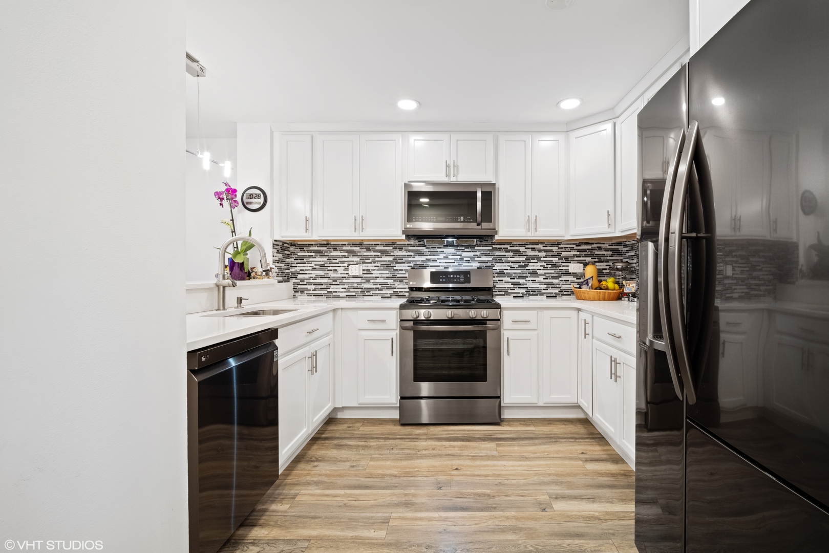 320 Sheridan Drive, Unit 2C Willowbrook, IL 60527 - Photo 7 of 20 a kitchen with stainless steel appliances a stove sink microwave and refrigerator