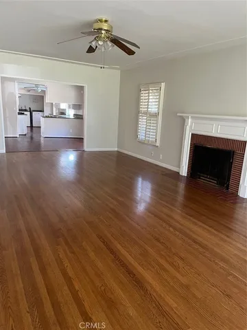 a view of empty room with wooden floor and fireplace