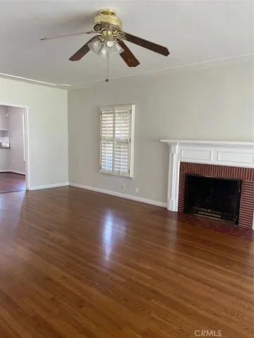 a view of empty room with wooden floor and fireplace