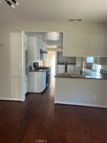 a kitchen with kitchen island a sink and wooden floor