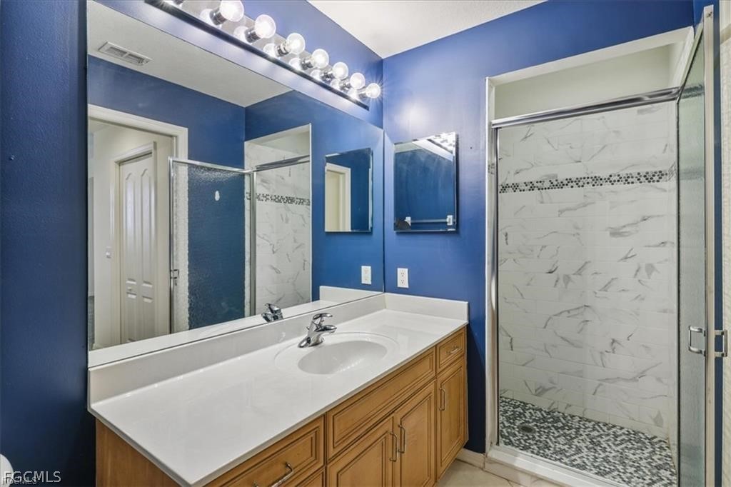 8261 Pathfinder Loop, Unit 738 Fort Myers, FL 33919 - Photo 12 of 22 a bathroom with a sink vanity granite shower and a mirror