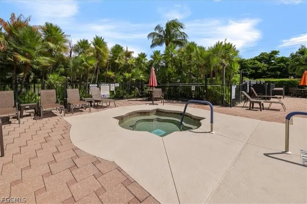 a view of a swimming pool with a lounge chair and palm trees