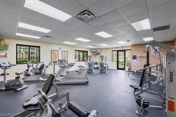 a living room with furniture gym equipment and a large window