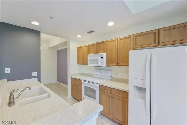 a kitchen with kitchen island a sink stainless steel appliances and cabinets