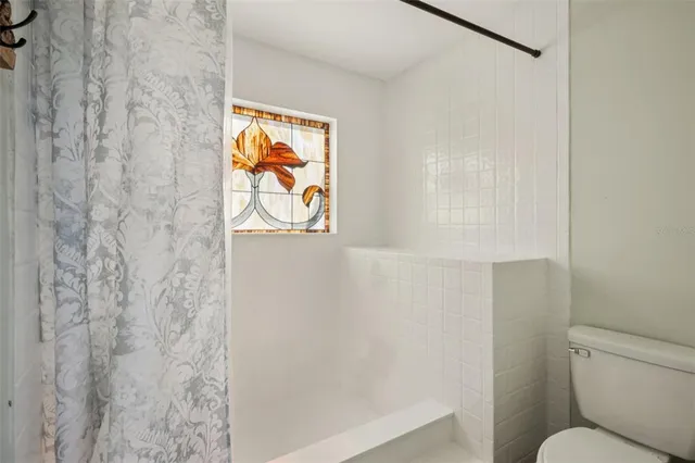 a bathroom with a toilet and a shower curtain