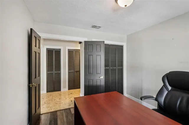 a bedroom with a bed and wooden floor