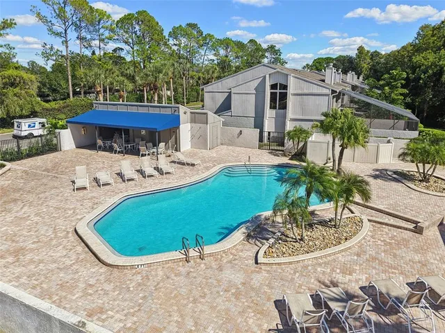 a view of a house with pool and trees in the background