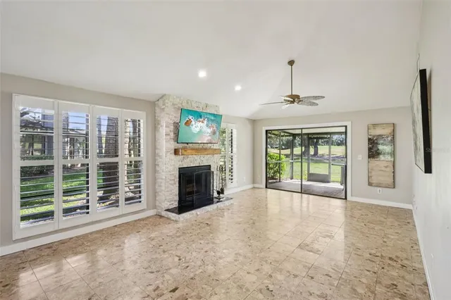 a view of an empty room with a fireplace and a window