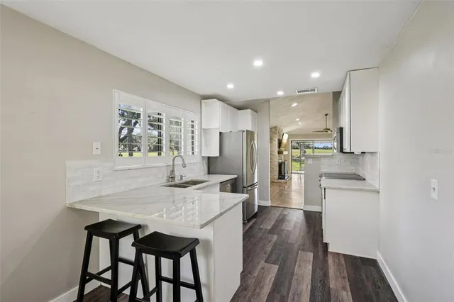 a kitchen with stainless steel appliances granite countertop a kitchen island hardwood floor and a sink