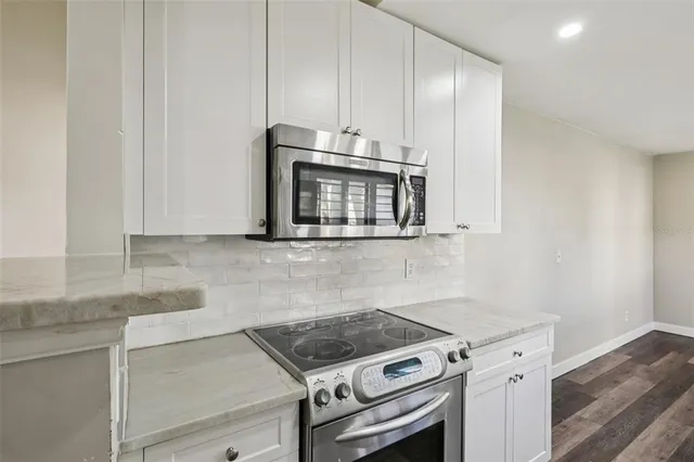 a kitchen with granite countertop a stove and a microwave