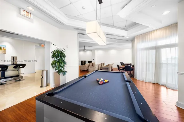 a room with wooden floor and potted plants