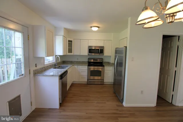 a kitchen with granite countertop a refrigerator and a sink