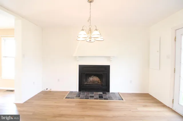 a living room with a fireplace and a chandelier