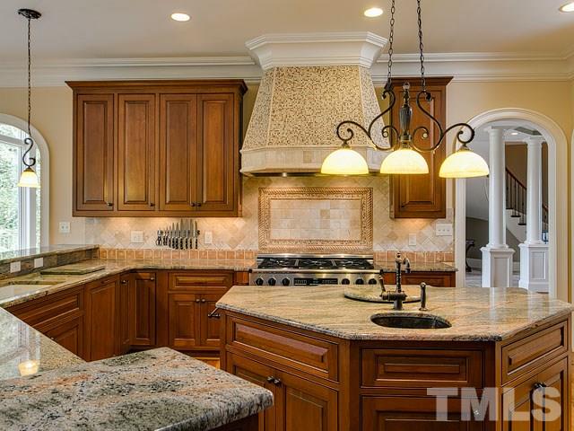 2309 Mt Vernon Church Road Raleigh, NC 27614 - Photo 9 of 25 a kitchen with stainless steel appliances granite countertop a sink a stove and a wooden cabinets