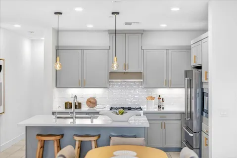 a kitchen with a sink a counter and a living room view