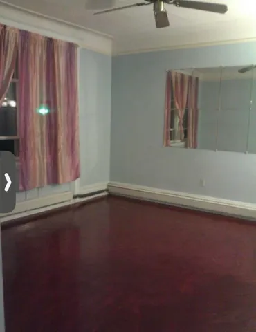a view of a livingroom with wooden floor and a window
