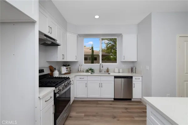 a kitchen with a sink a stove and cabinets