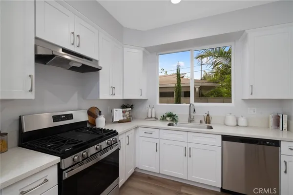 a kitchen with cabinets appliances a sink and a window