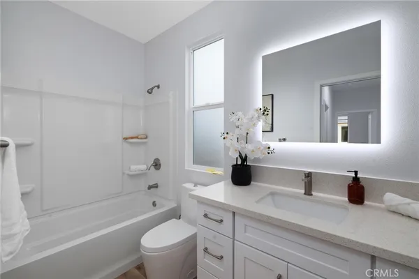 a bathroom with a double vanity sink toilet mirror and bathtub