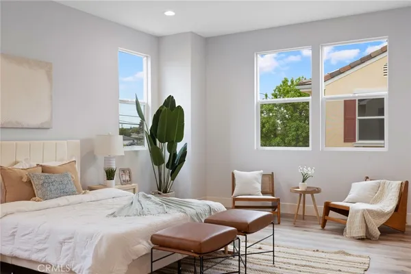 a bedroom with a bed a window and potted plant