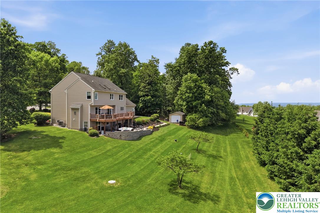 115 West Butternut Road Hellertown, PA 18055 - Photo 66 of 97 A spacious yard with verdant lawns slopes gently from the multi-level deck of a welcoming residence.