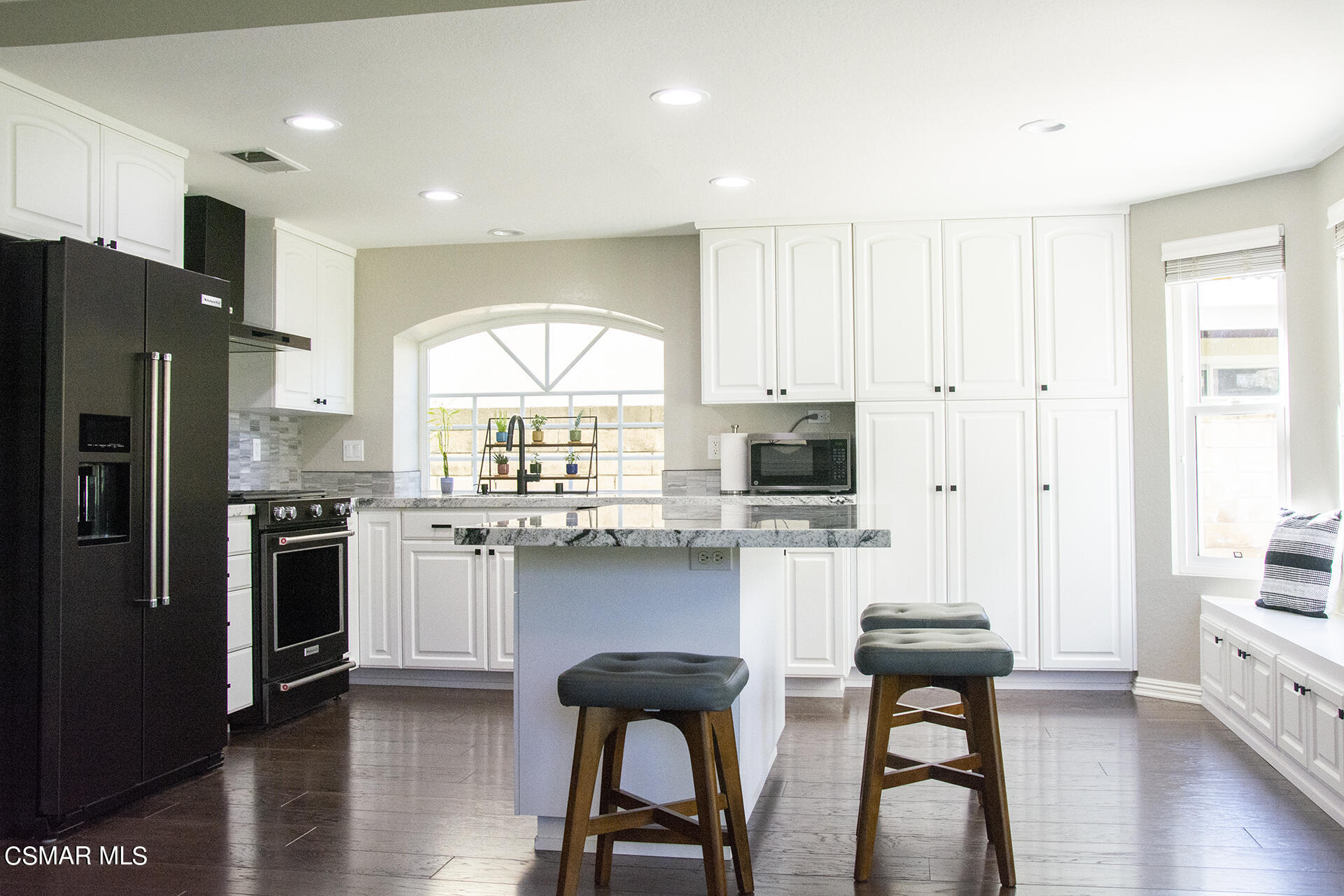 685 Overlook Road Simi Valley, CA 93065 - Photo 17 of 37 a kitchen with stainless steel appliances kitchen island granite countertop a table chairs refrigerator and microwave