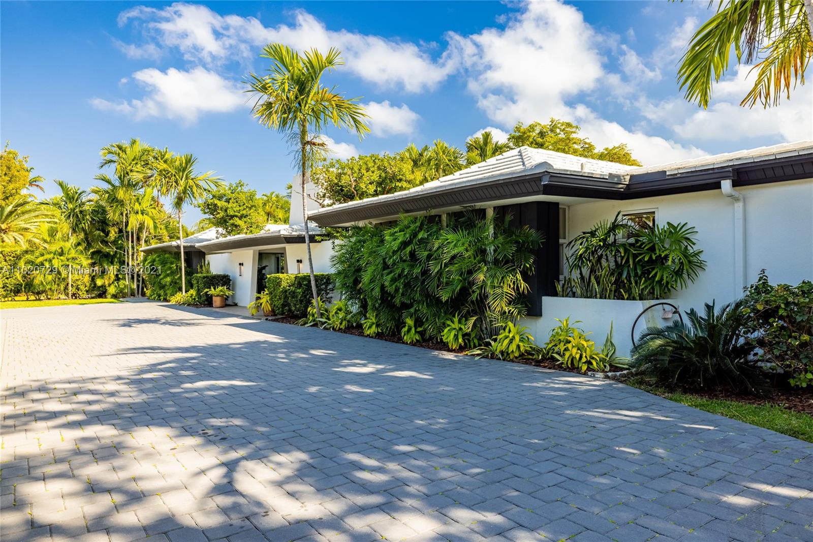 4765 Lake Road Miami, FL 33137 - Photo 5 of 100 a front view of a house with a yard and potted plants