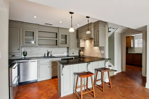 a living room with stainless steel appliances kitchen island granite countertop furniture and a view of kitchen