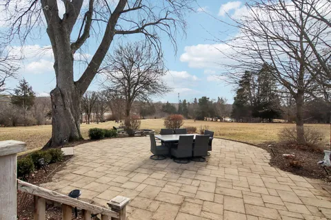 an aerial view of a house with garden space and trees all around