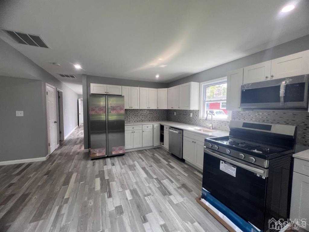 1577 Holly Road North Brunswick, NJ 08902 - Photo 14 of 15 a kitchen with stainless steel appliances granite countertop a stove a sink and a refrigerator