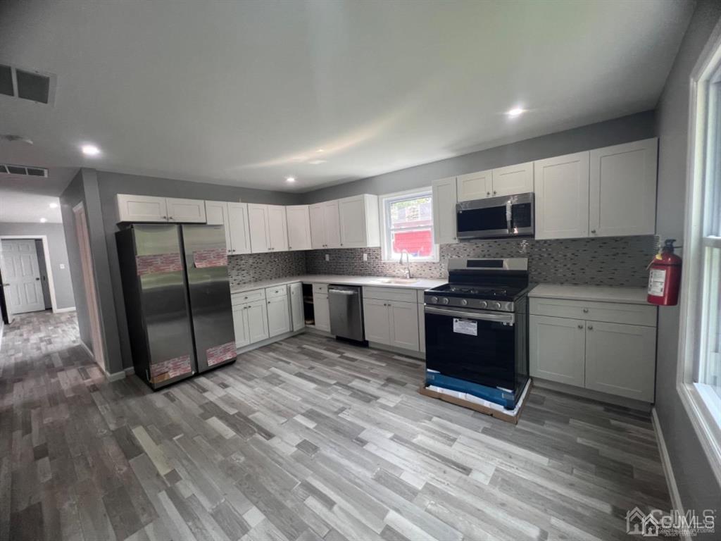 1577 Holly Road North Brunswick, NJ 08902 - Photo 15 of 15 a kitchen with stainless steel appliances a refrigerator sink and microwave