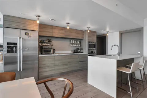 a kitchen with kitchen island a counter top space a sink stainless steel appliances and cabinets