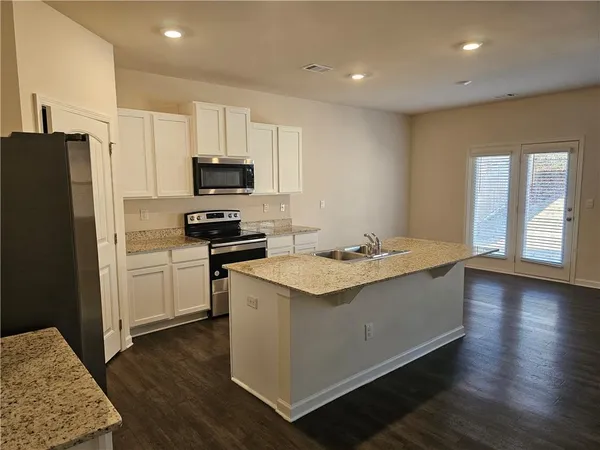 a kitchen with granite countertop a sink and a stove top oven