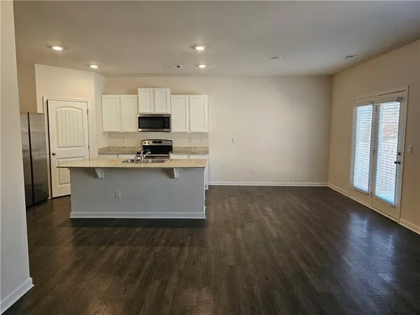 a large kitchen with stainless steel appliances granite countertop a stove a sink and a refrigerator