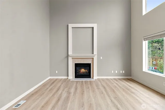 a view of an empty room with window and fire place