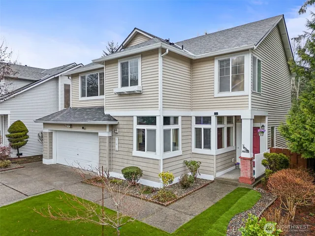 a front view of a house with a yard and garage