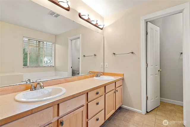 a spacious bathroom with a double vanity sink and a mirror