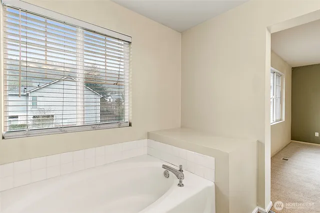 a white bath tub sitting next to a window