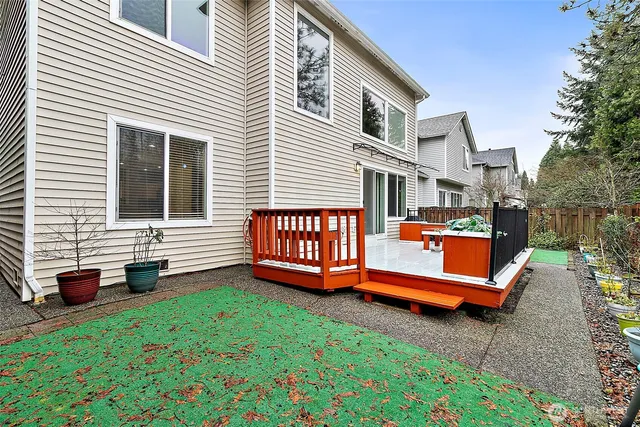 a backyard of a house with barbeque and wooden fence