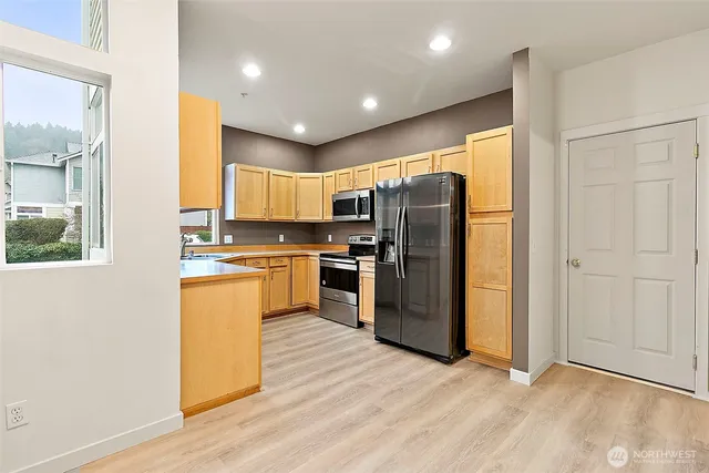 a kitchen with stainless steel appliances granite countertop a refrigerator and a stove top oven