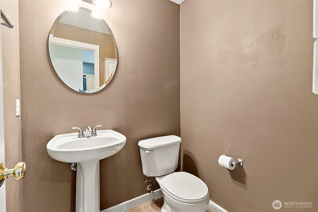 a bathroom with a toilet sink and mirror