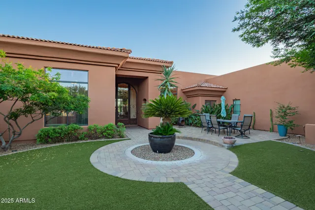a view of a chair and table in backyard of the house